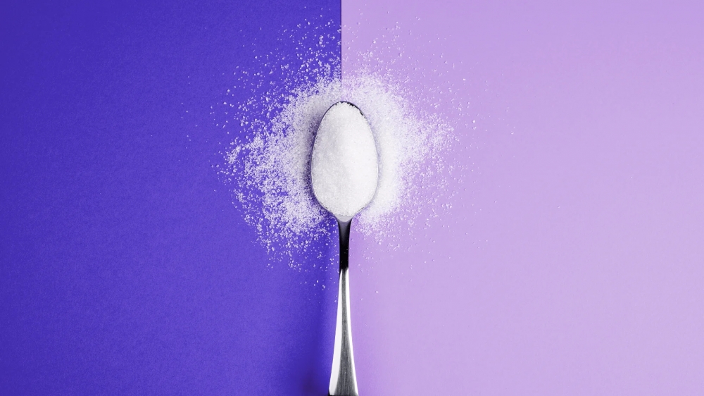 Allulose granules on a spoon