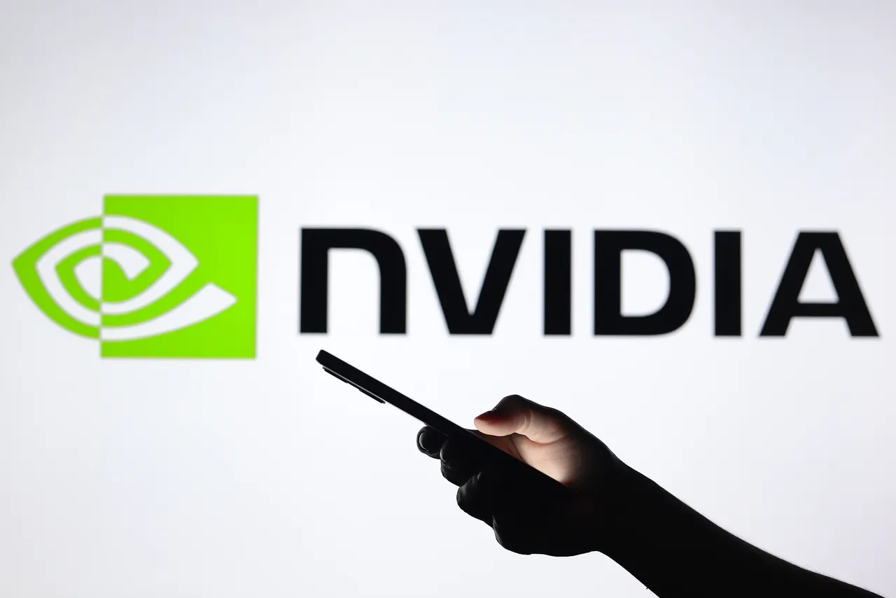 A person on their smartphone with the Nvidia logo in the background.