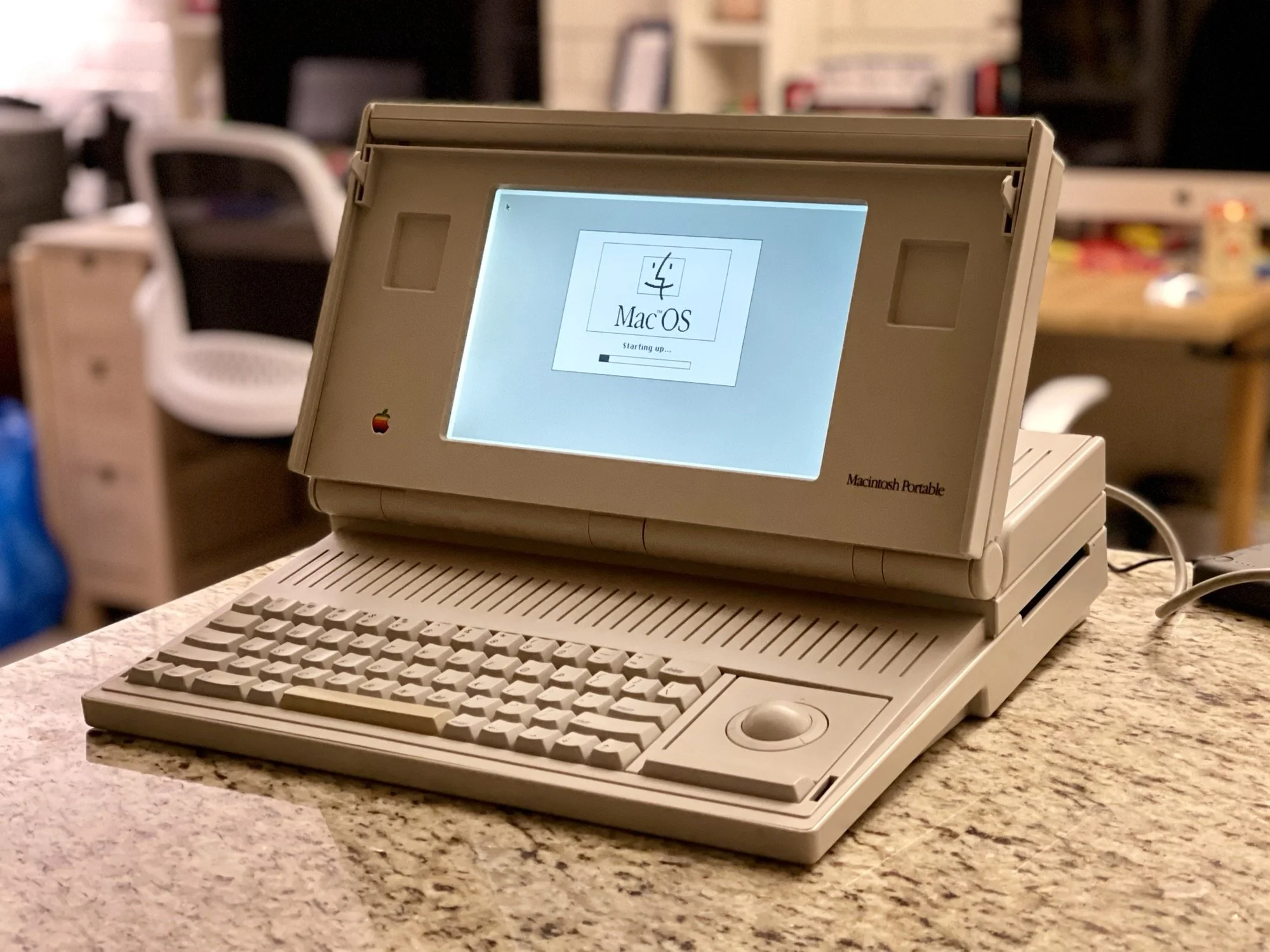 Apple's Macintosh Portable, a pioneering device in portable computing, heavy but innovative for its time.