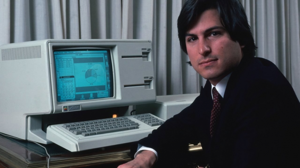 Steve Jobs himself sitting in front of the Apple Lisa.