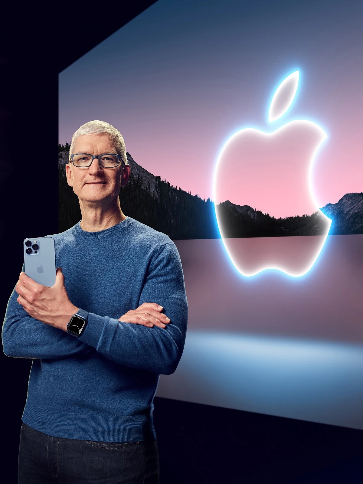 Tim Cook Standing In Front Of The Apple Logo Holding An iPhone