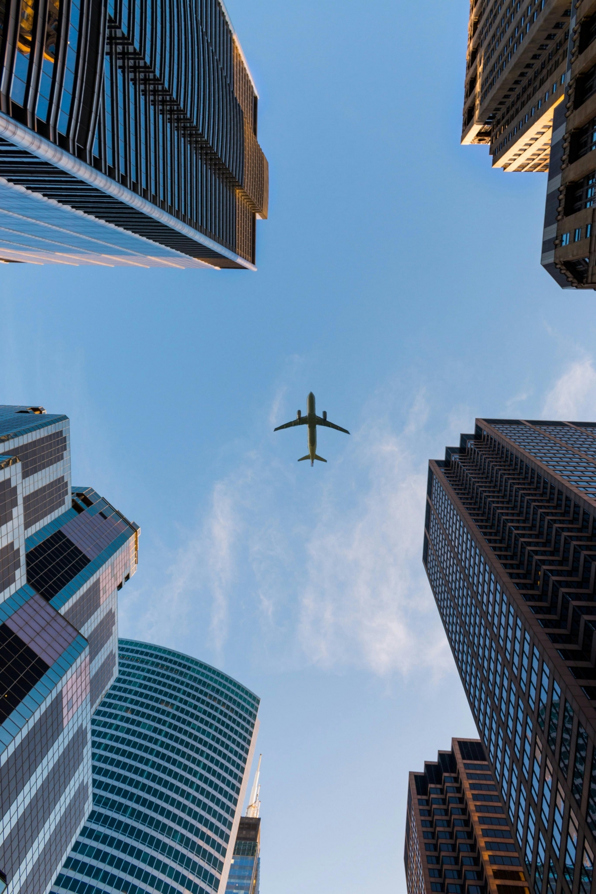 A Plane Flying Over The City Photographed From Below