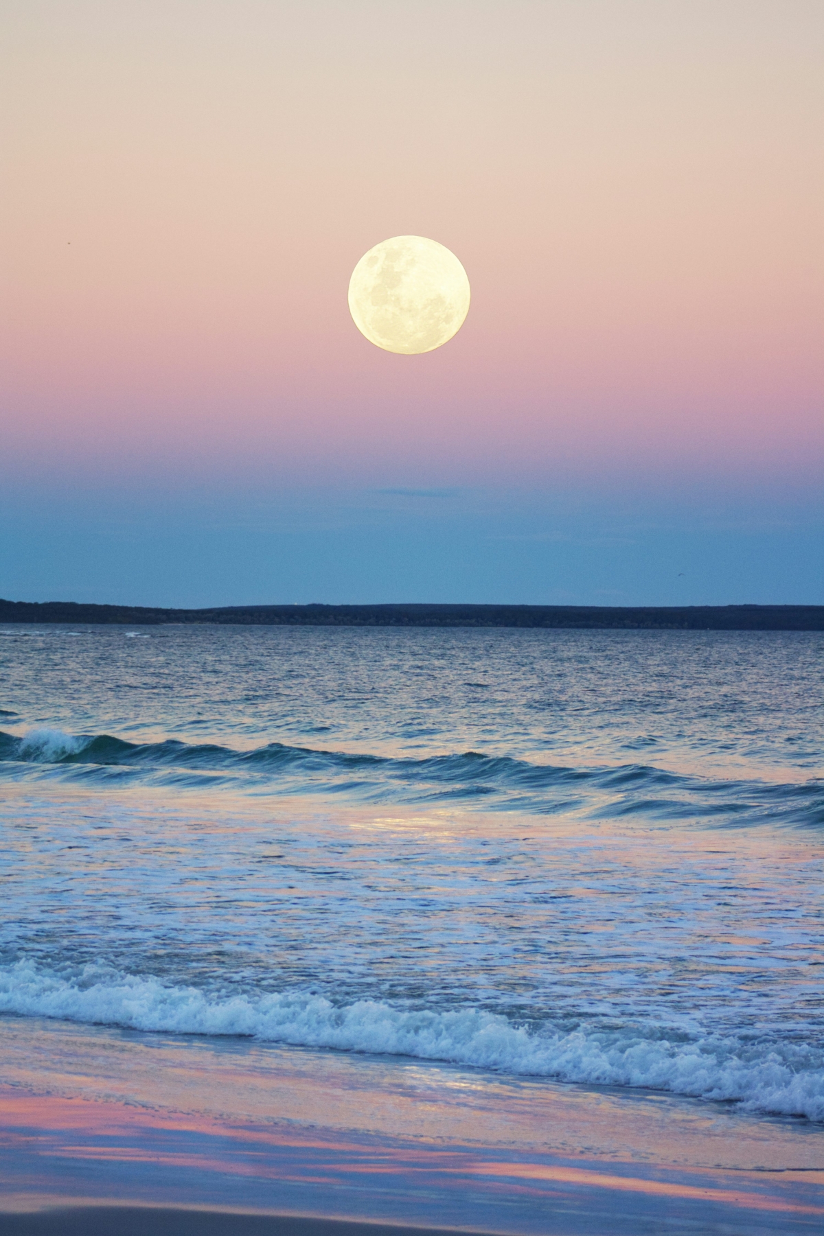 Moon At Sunset Over The Waves And Ocean At The Beach