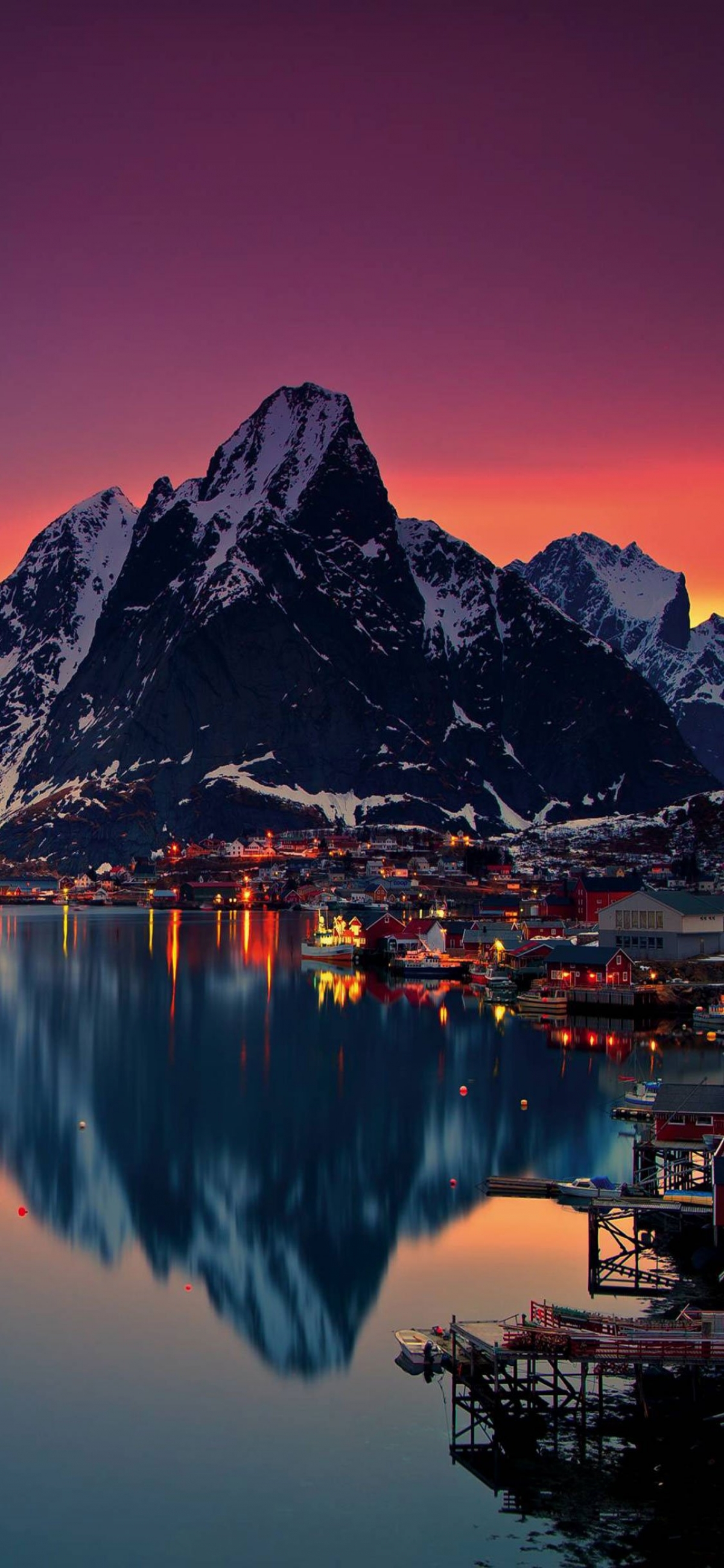 Snow Covered Mountain At Sunset With Town Lights