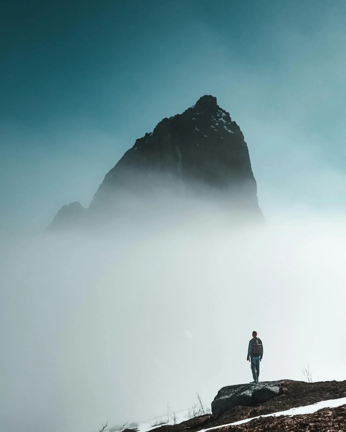 Mountain Emerging From Clouds While Man Looks On wallpaper for Apple iPhone, Apple Watch, Mac, iPad and Apple Watch