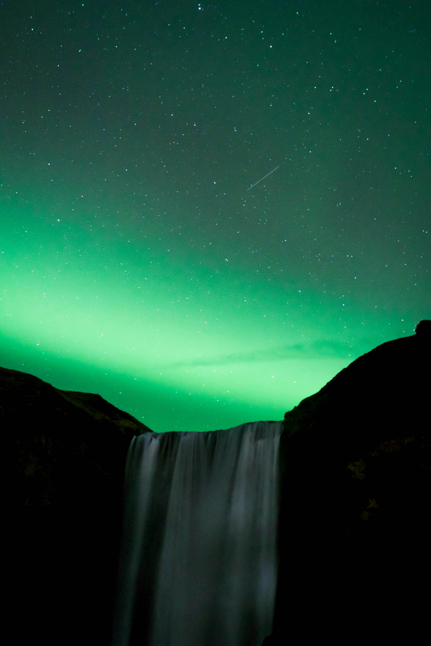 Aurora Borealis Vibrant Green Above A Waterfall Northern Lights