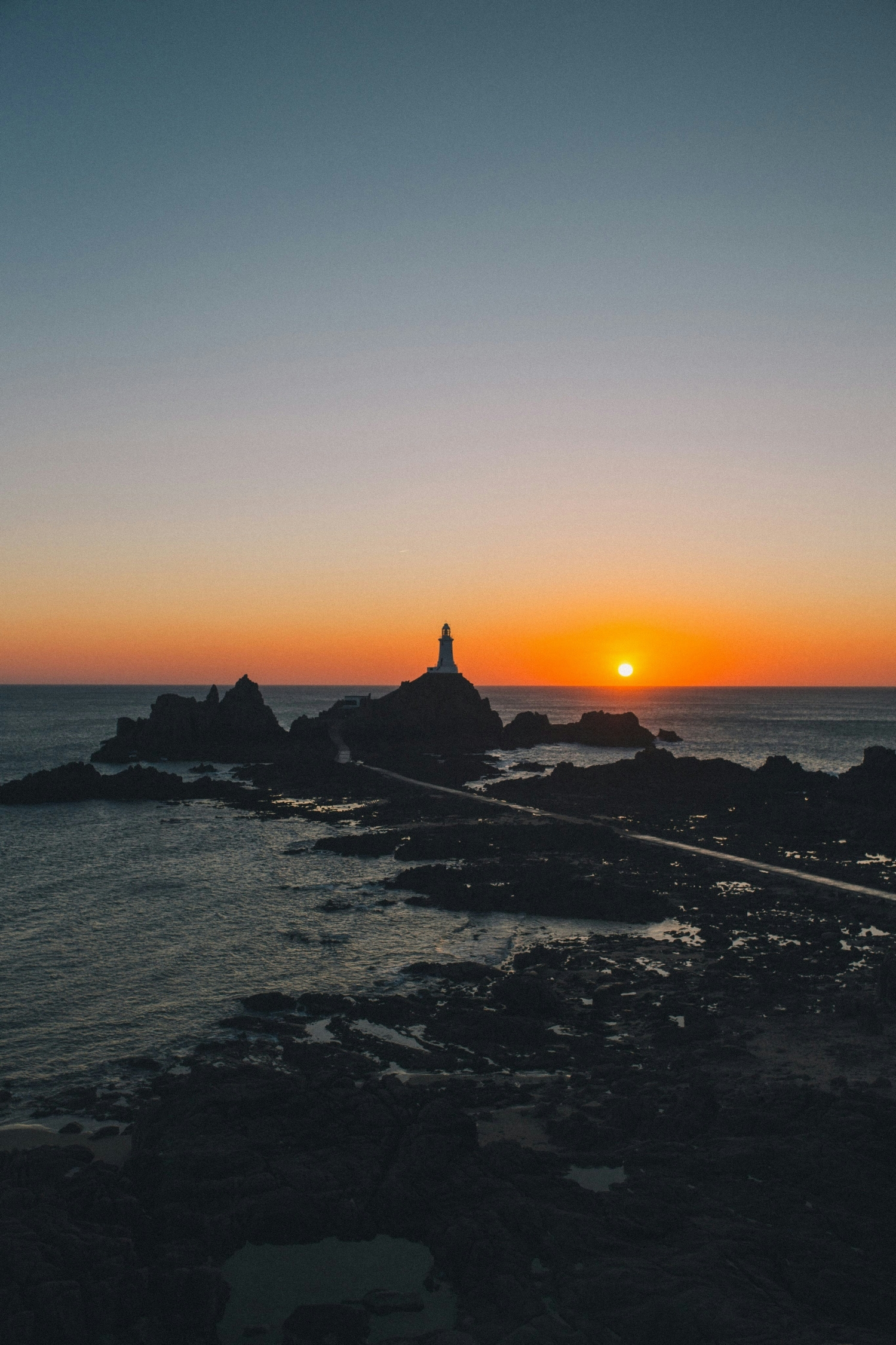 Lighthouse At Sunset On The Rocks