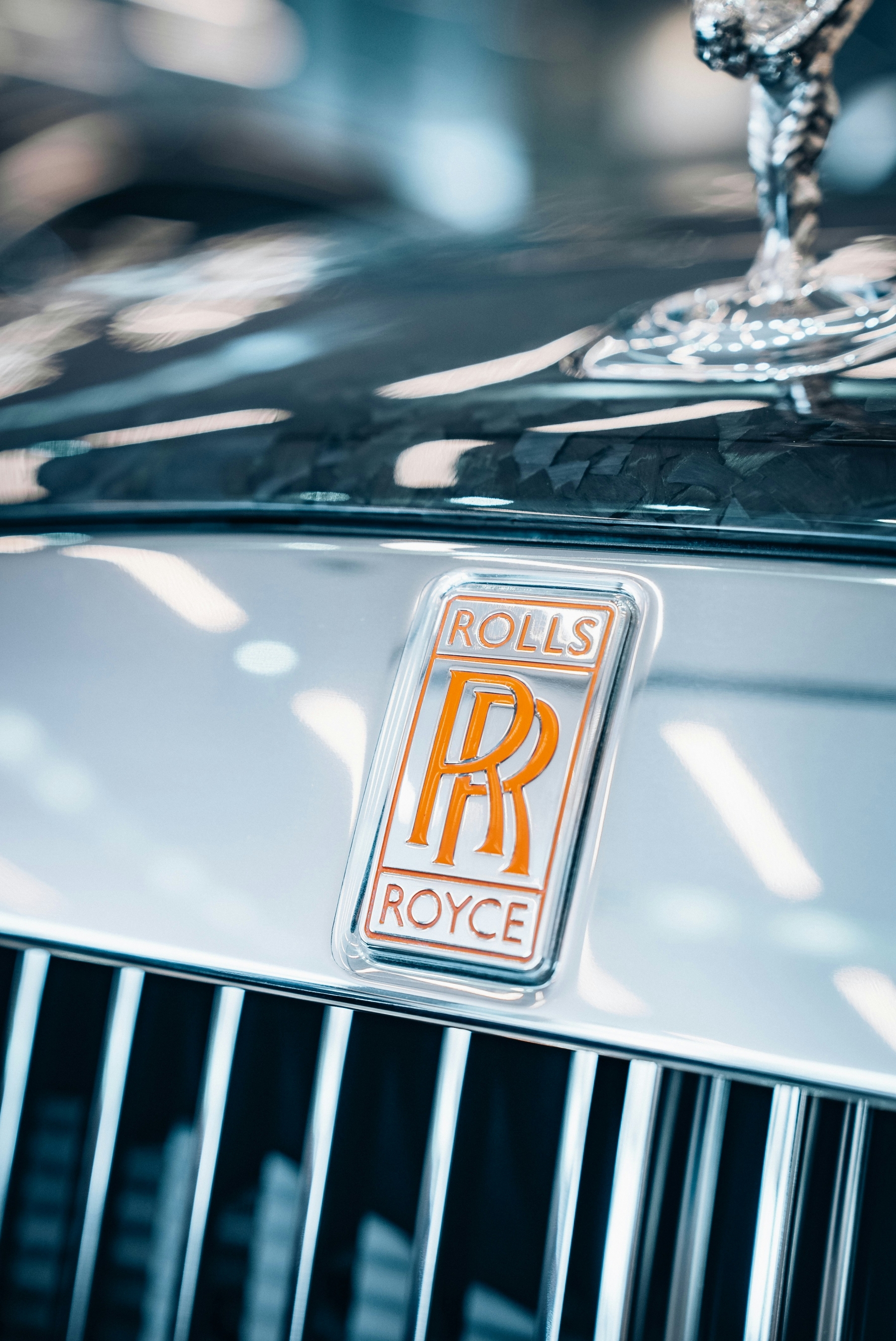 Orange Rolls Royce Front Of Car Logo