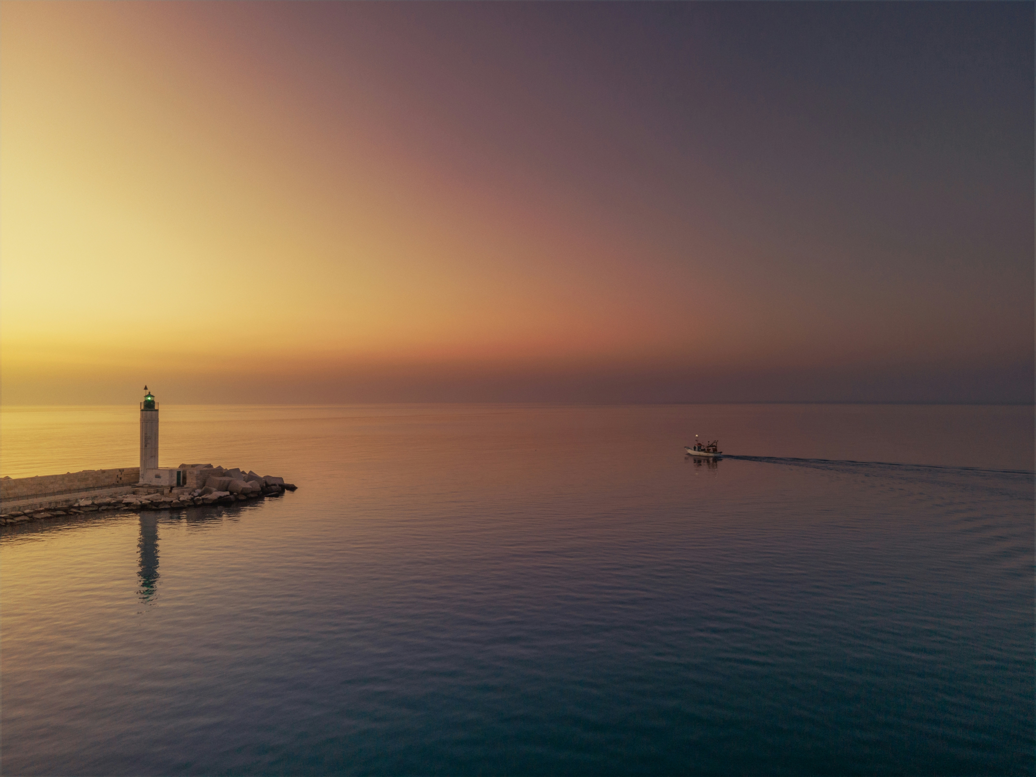 A Lighthouse Against A Hazy Sunset wallpaper for Apple iPhone, Apple Watch, Mac, iPad and Apple Watch