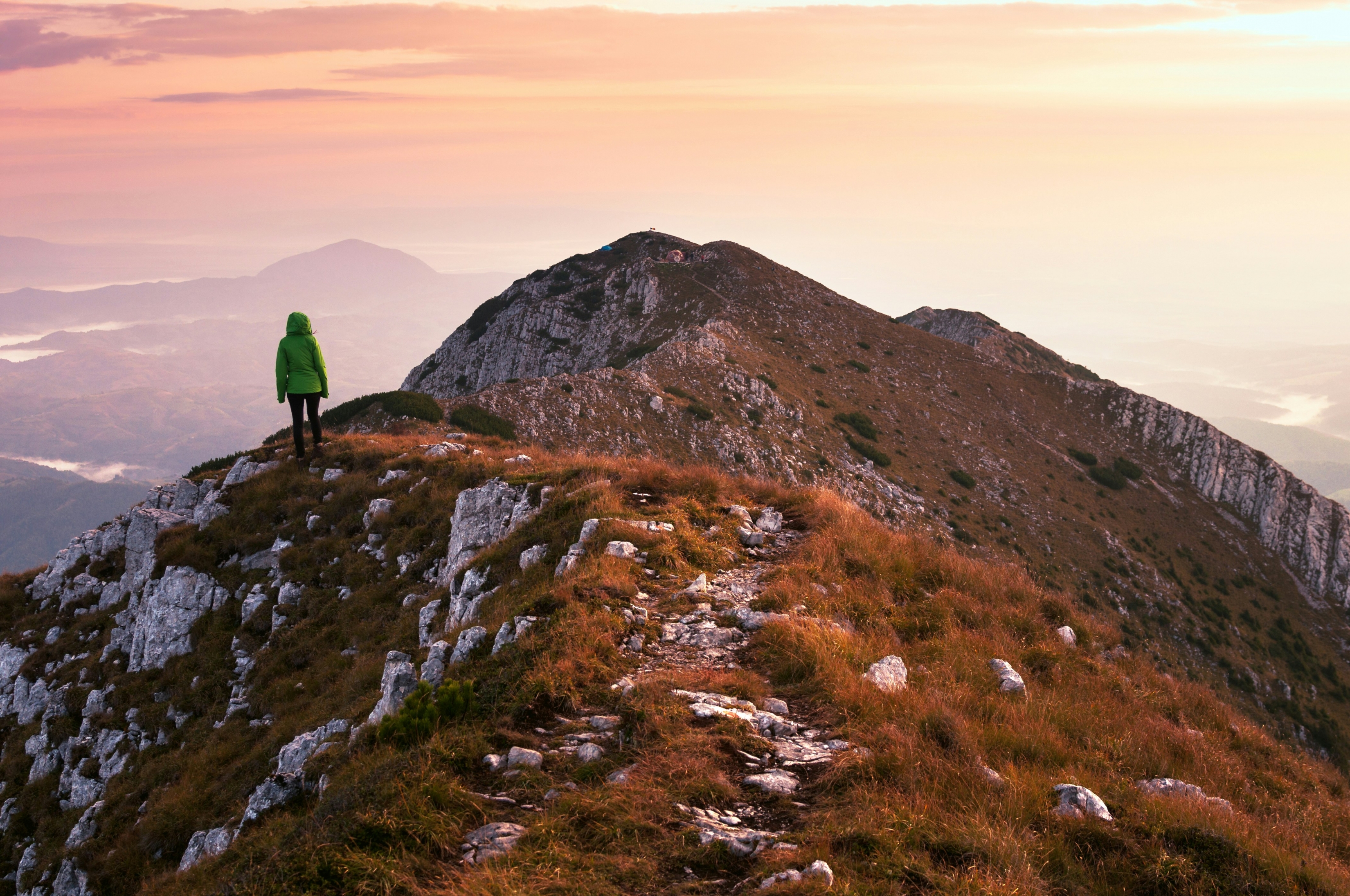 A Woman Hiking On A Mountain At Dusk