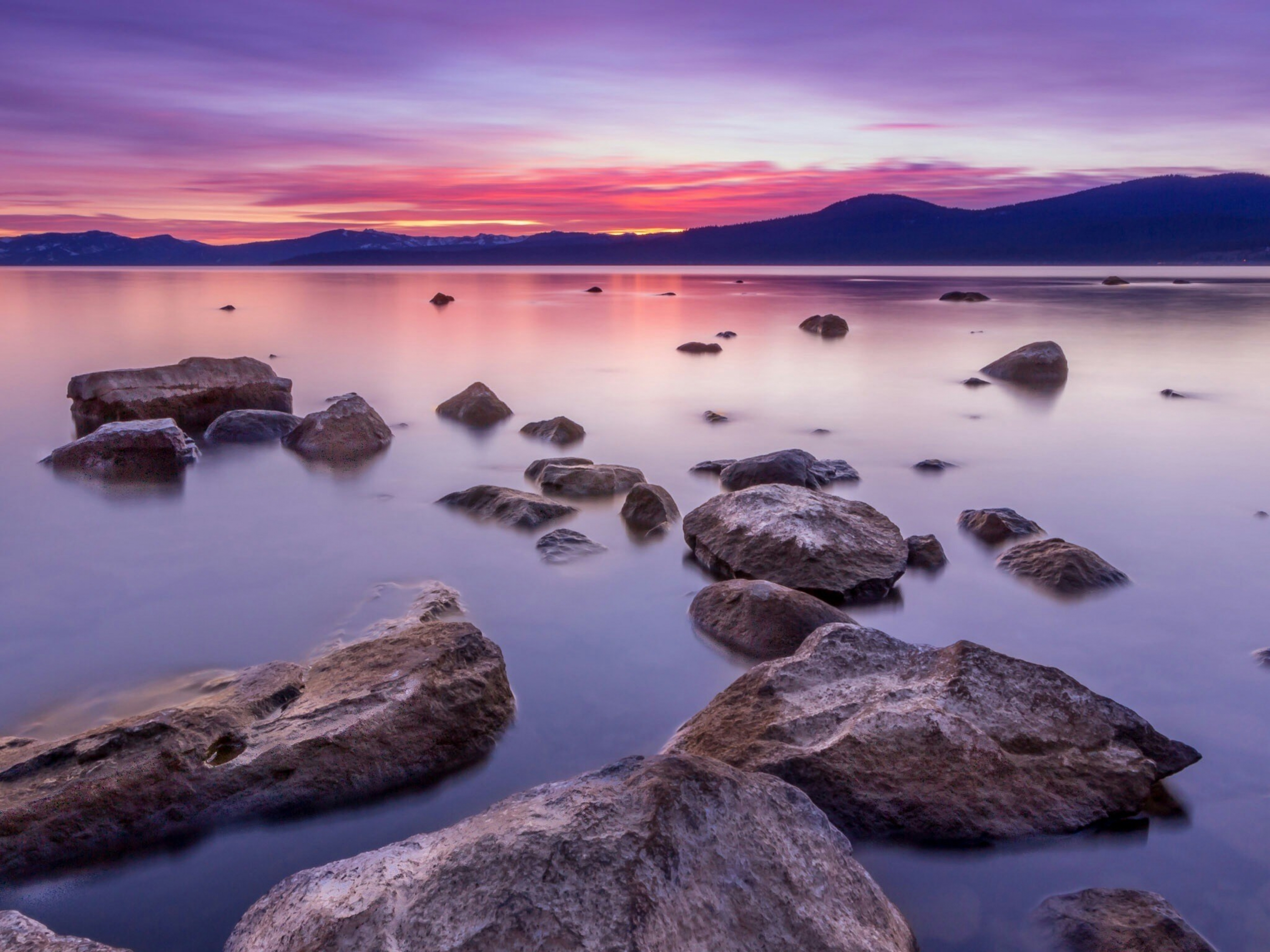 Colorful Sunset Reflects On A Rocky Body Of Water