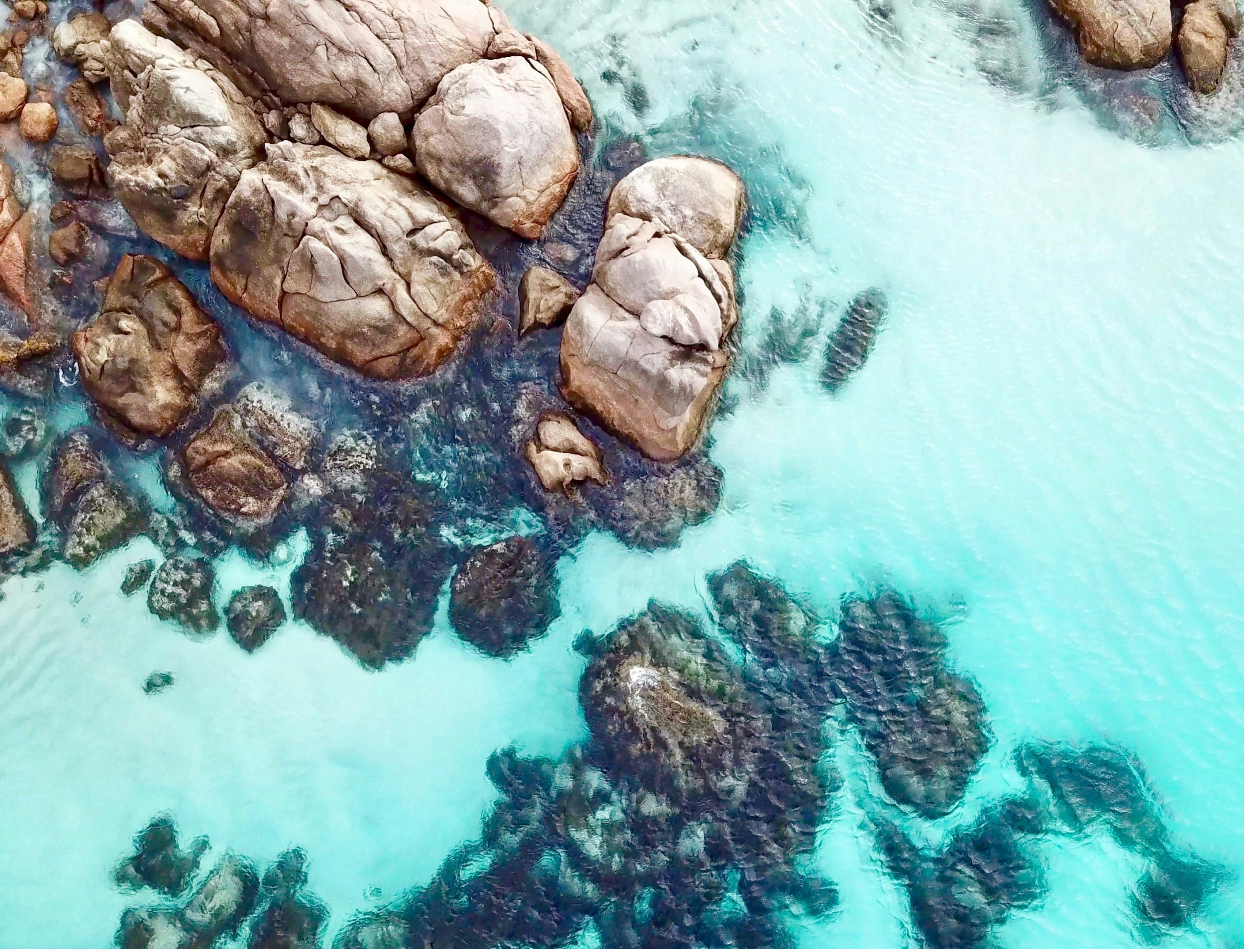 Crystal Clear Blue Water From Above Rocky Beach