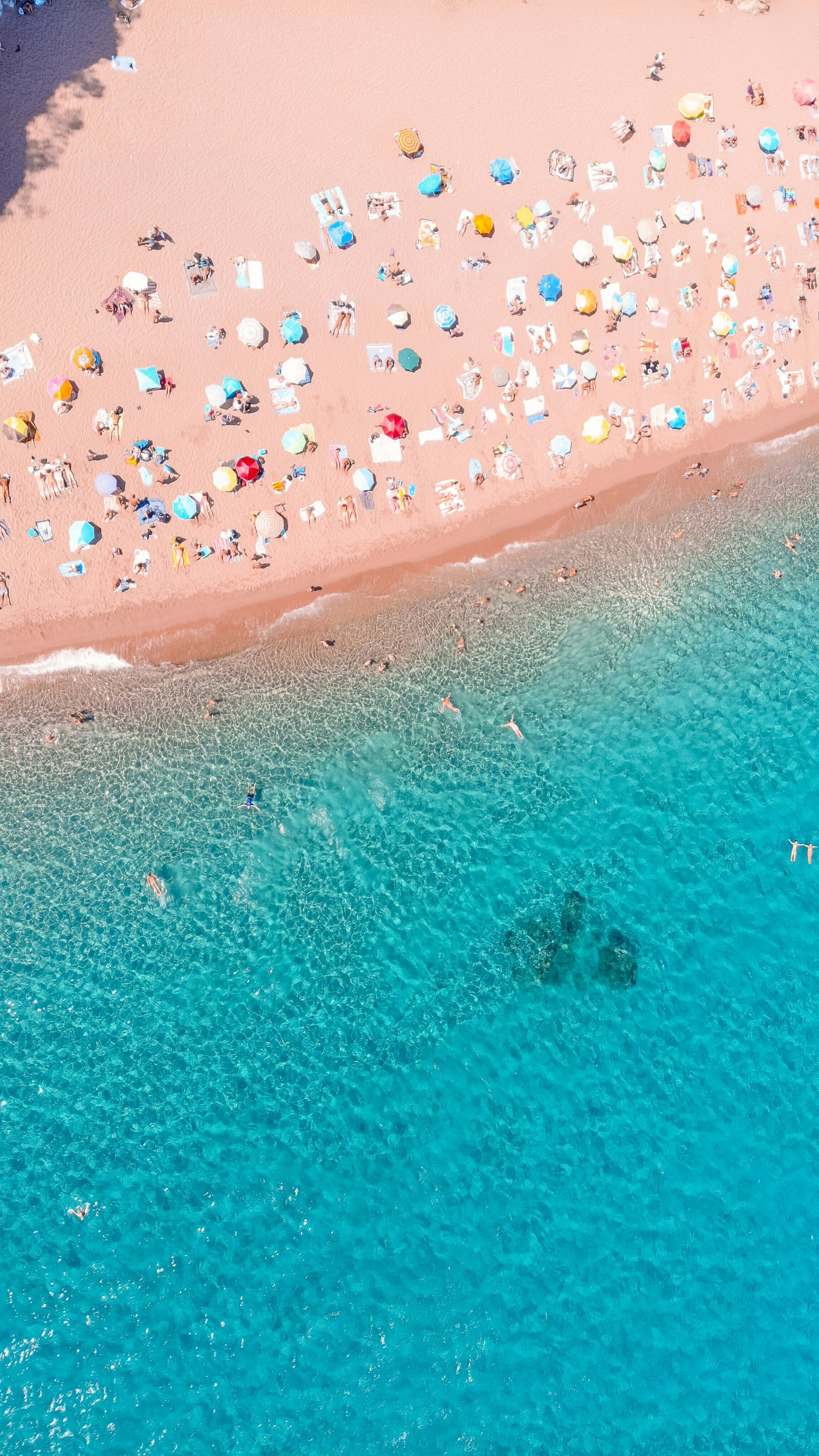 Crystal Clear Water Beach With Colorful Umbrellas Shot From Above