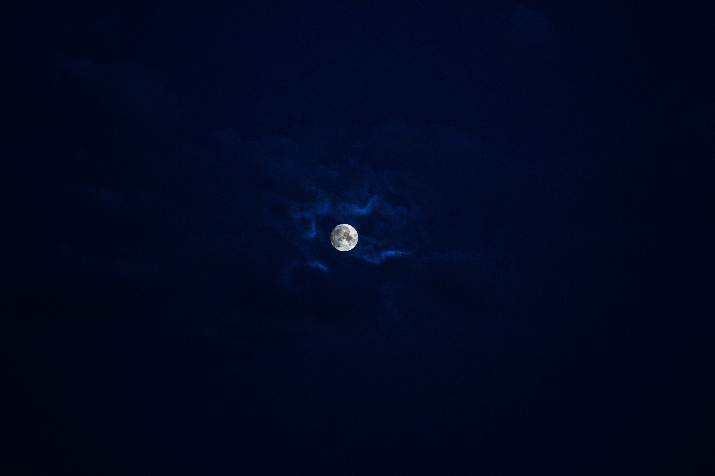 Dark Blue Moon Among Clouds