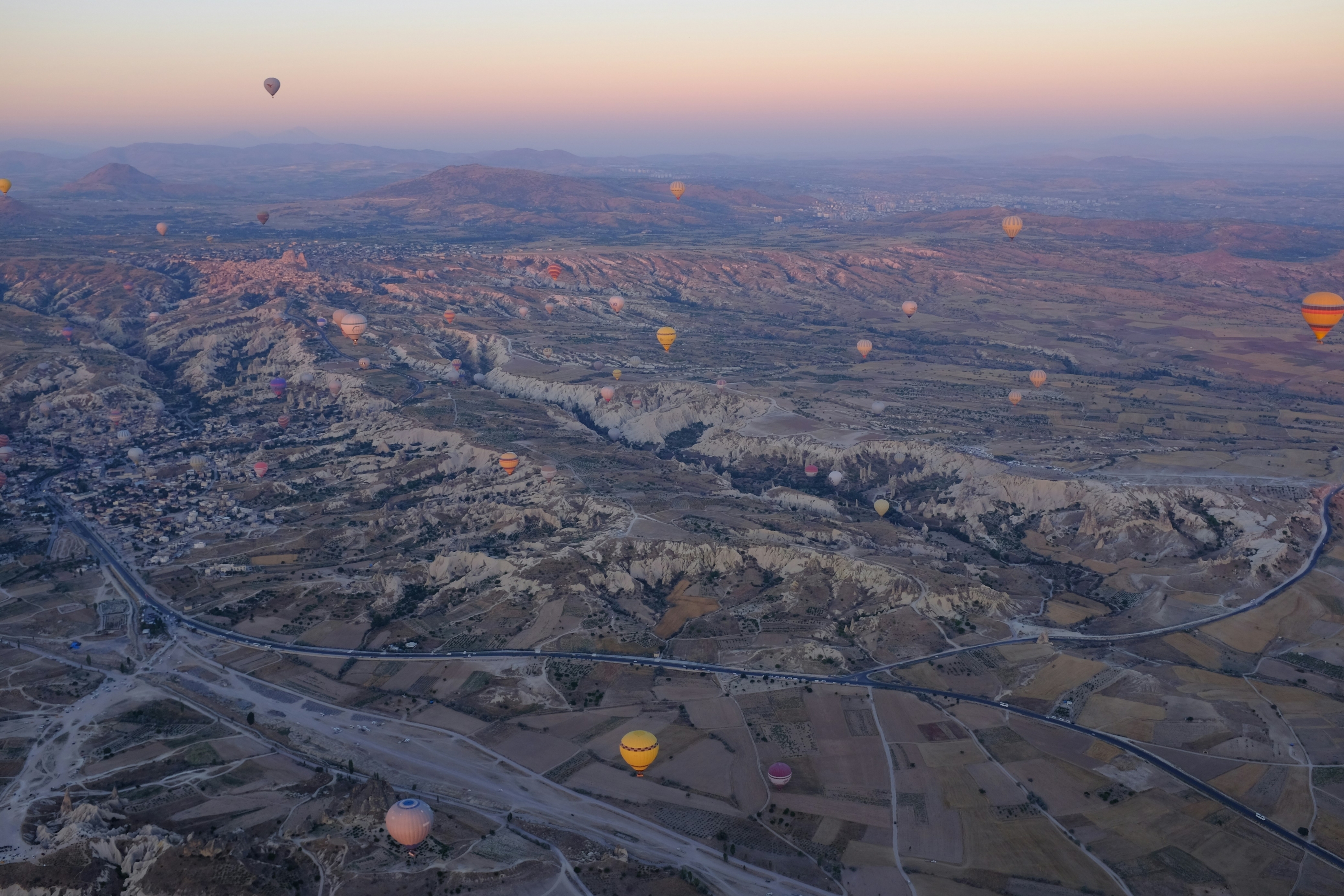 Hot Air Balloons Fly Over A Barren Sunrise Landscape