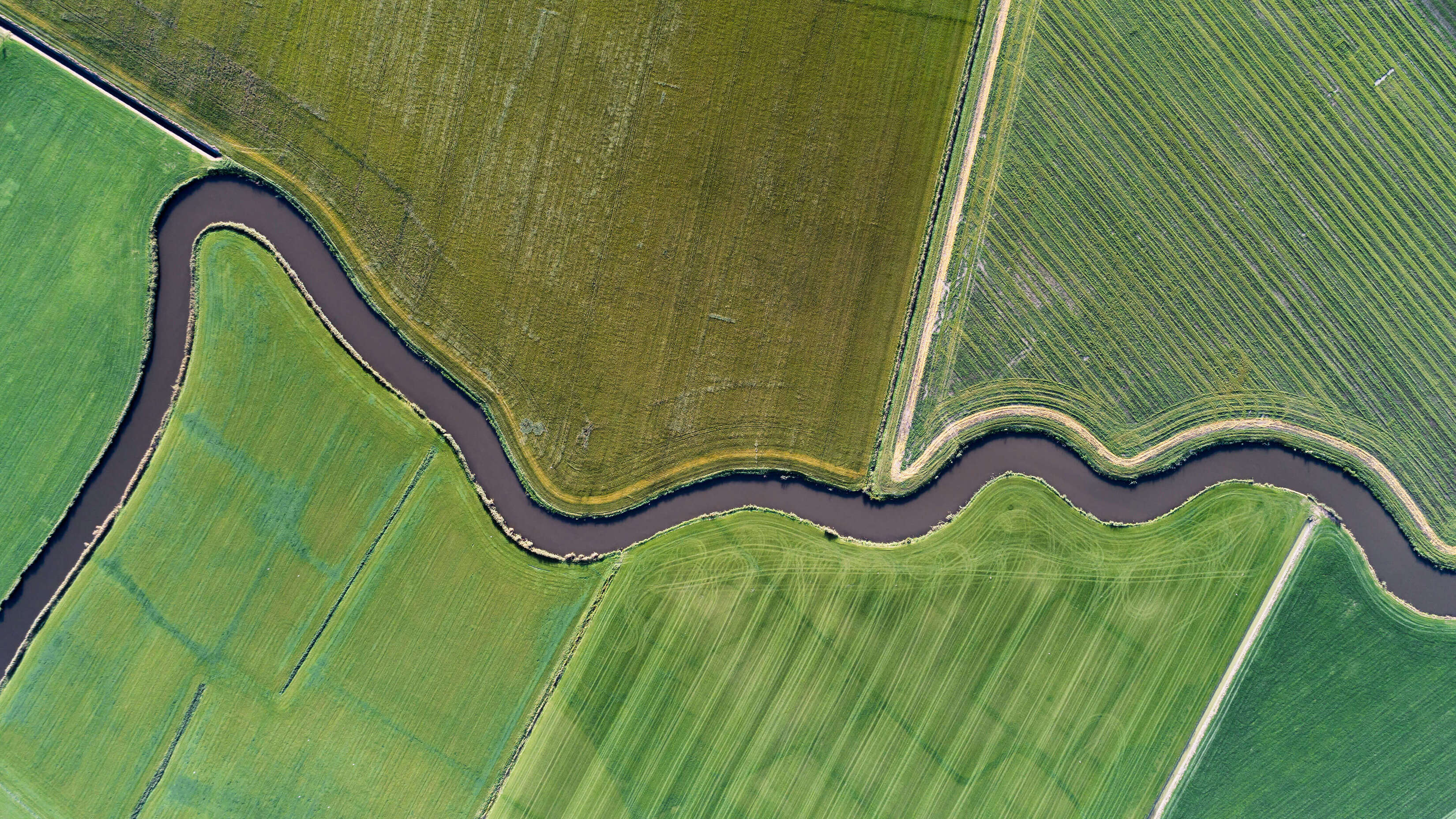 Microsoft Windows HD 11 Stock Aerial Farm Shot River Through Rolling Pastures wallpaper for Apple iPhone, Apple Watch, Mac, iPad and Apple Watch