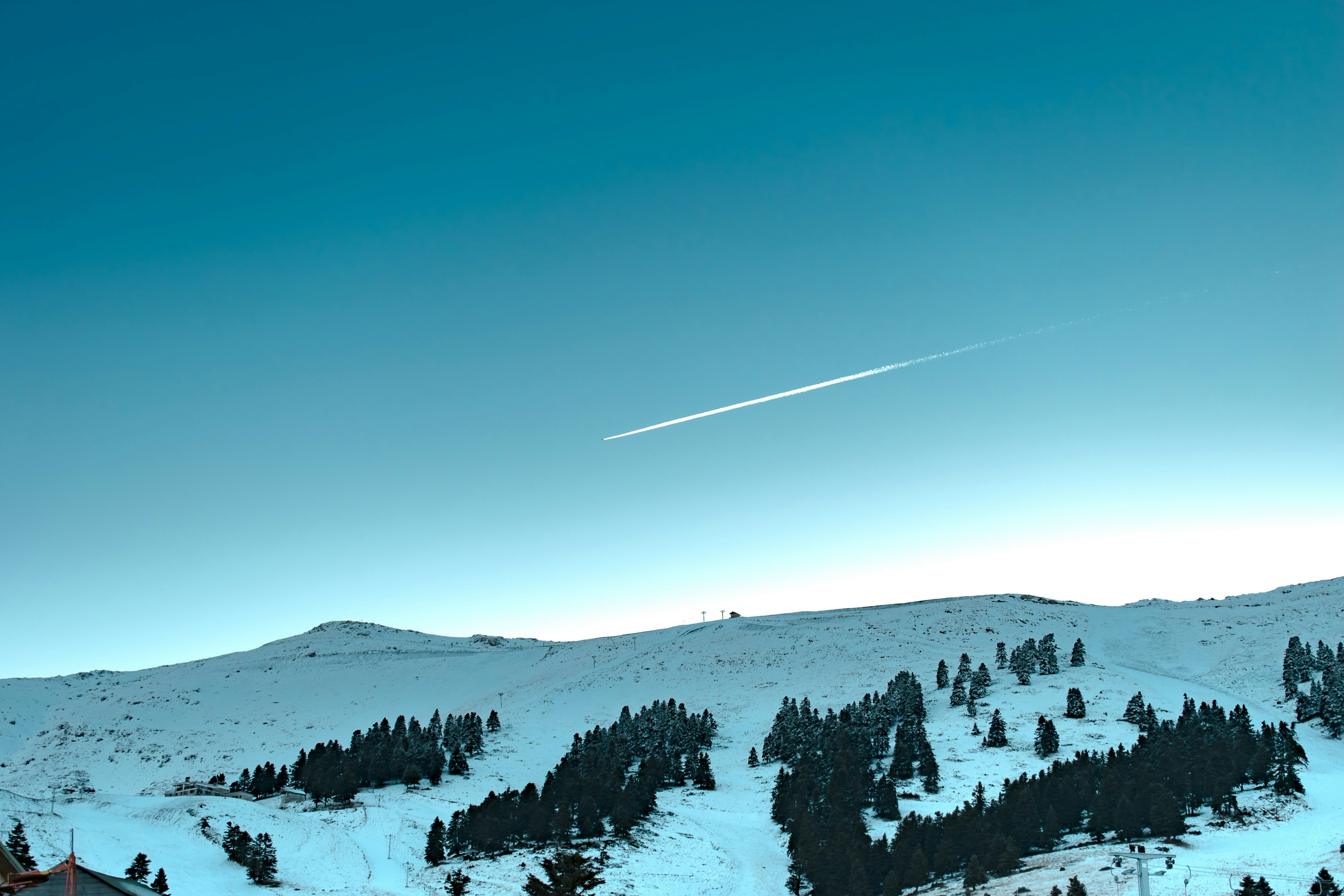 Shooting Star Plane Contrail Over Snowcapped Mountains And Trees