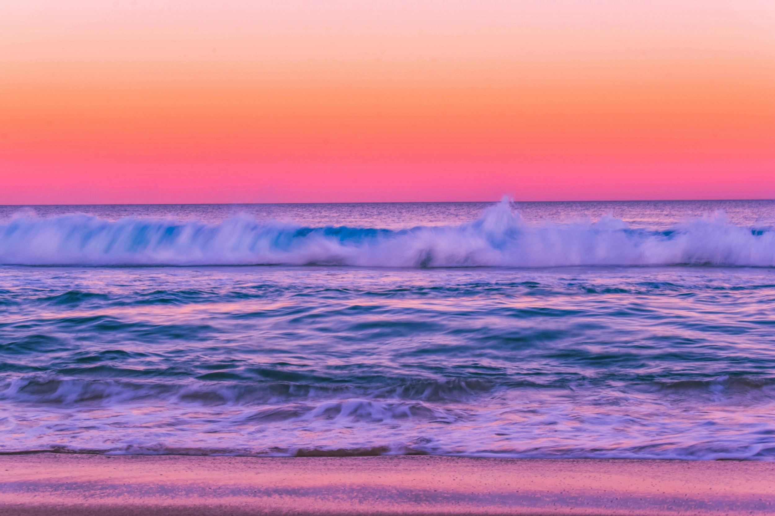 Super Vibrant Waves Crashing Onto The Sand At The Beach At Sunset