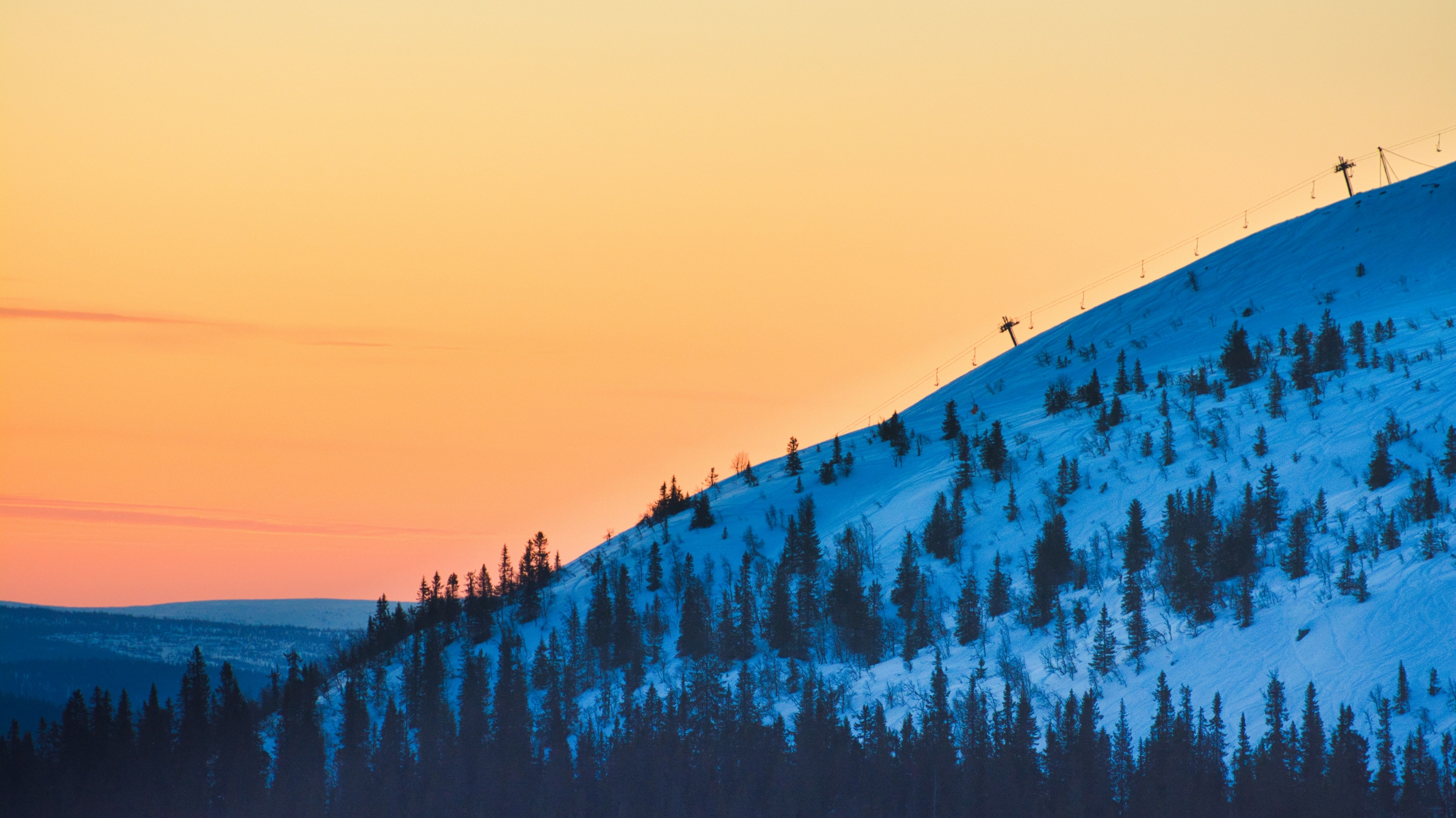 Vibrant Orange Sunset Over A Snowcapped Mountain