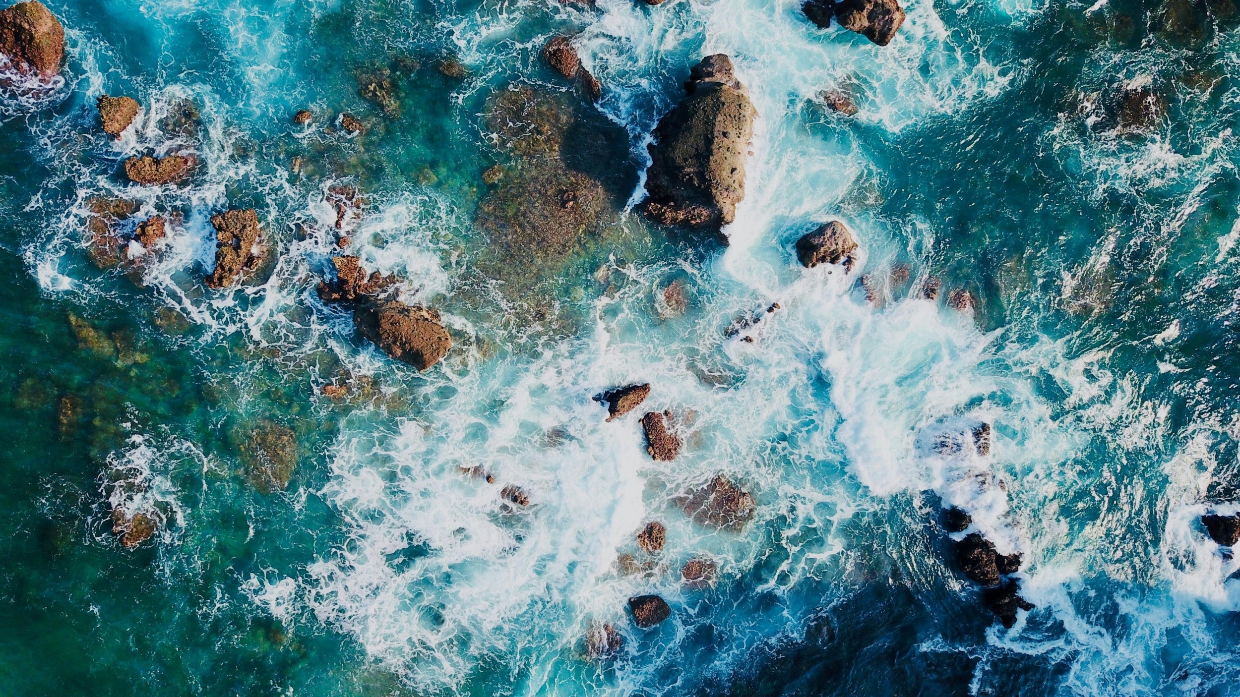 Waves Crashing On A Rock Beach From Above Drone Shot